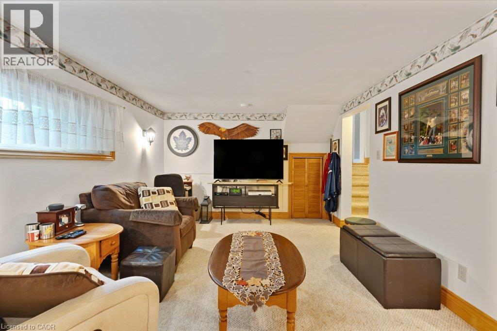 Carpeted floor, neutral wall paint, wood-finish bi-fold doors, and a wall-mounted sconce - 236 Winston Boulevard, Cambridge, ON - Indoor