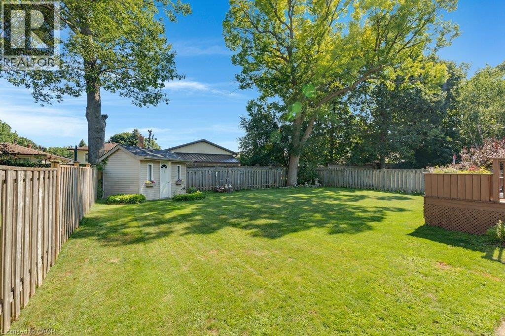 Expansive lawn area, perimeter fencing, mature trees, storage shed, and a composite deck with lattice skirting - 236 Winston Boulevard, Cambridge, ON - Outdoor With Backyard