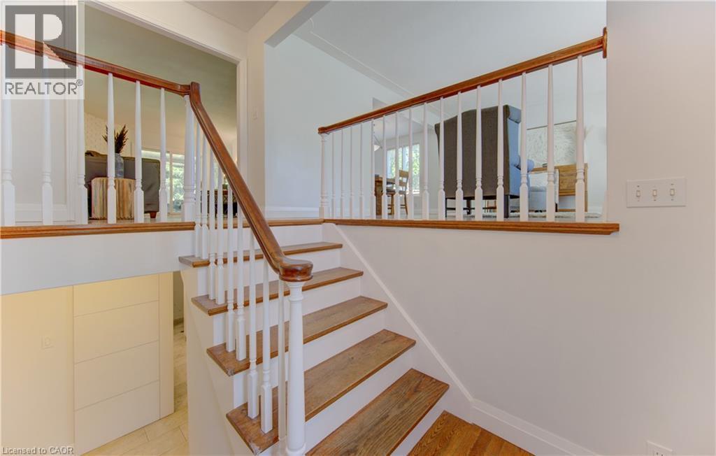 Hardwood staircase with white risers and balusters - 106 Autumn Hill Crescent, Kitchener, ON - Indoor Photo Showing Other Room