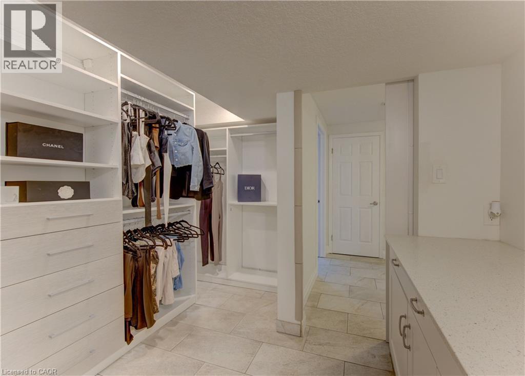 Custom closet system featuring multiple hanging rods, integrated shelving, and drawer storage - 106 Autumn Hill Crescent, Kitchener, ON - Indoor