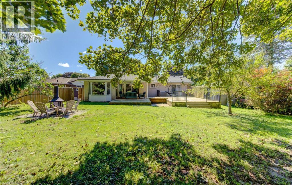 Expansive green lawn with mature trees and a private wooden fence - 106 Autumn Hill Crescent, Kitchener, ON - Outdoor