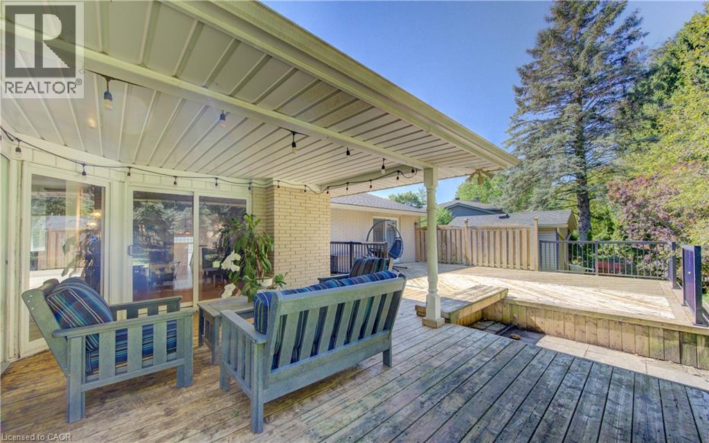 Multi-level outdoor wooden decking featuring a covered patio, string lighting, and direct access to interior spaces via sliding glass doors - 106 Autumn Hill Crescent, Kitchener, ON - Outdoor With Deck Patio Veranda With Exterior