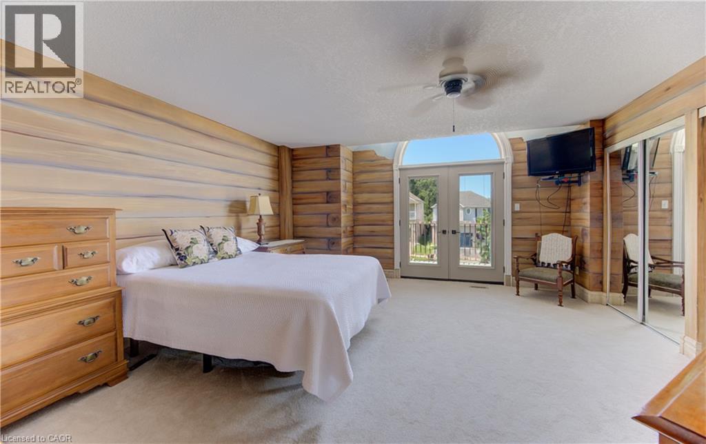 Spacious primary bedroom showcasing warm wood-finish walls and built-in cabinetry - 74 Forest Edge Trail, Kitchener, ON