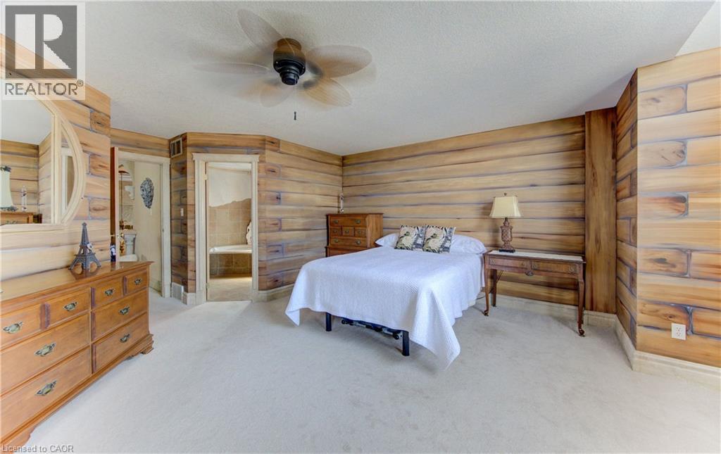 Carpeted room featuring wood-paneled walls and a ceiling fan - 74 Forest Edge Trail, Kitchener, ON