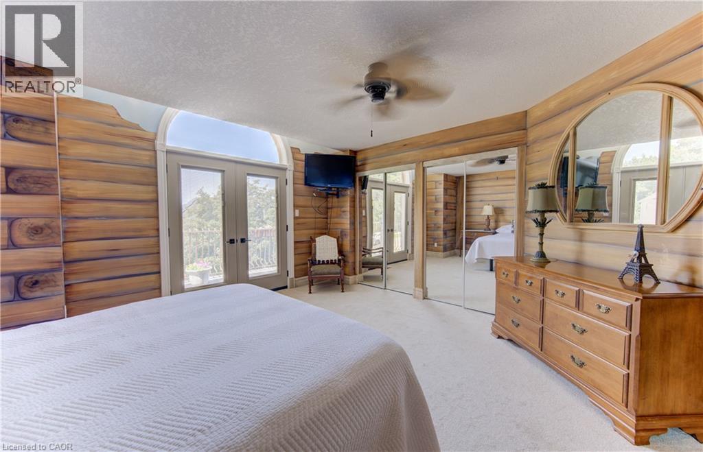 Interior space featuring wood-finish wall paneling, a ceiling fan, and light-colored carpet flooring - 74 Forest Edge Trail, Kitchener, ON