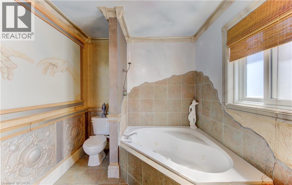 Spacious bathroom featuring a corner jetted soaking tub with tile surround - 74 Forest Edge Trail, Kitchener, ON