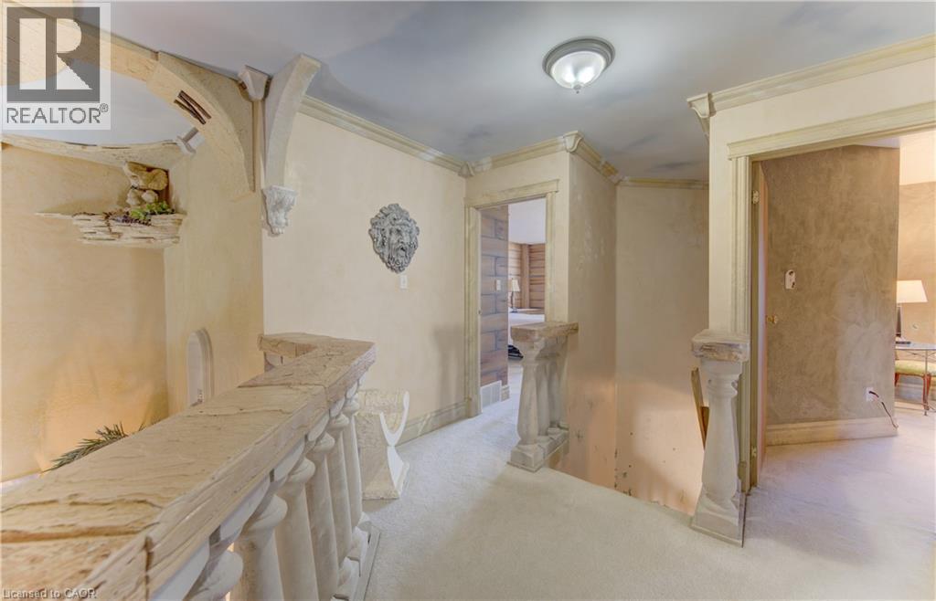 Hallway featuring textured walls, stone balusters, decorative ceiling accents, and arched entryways - 74 Forest Edge Trail, Kitchener, ON