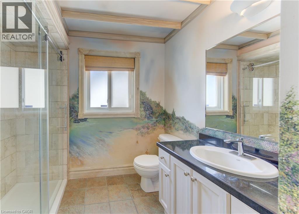 Bathroom featuring a glass-enclosed shower, single vanity with a dark countertop and undermount sink, a toilet, and tiled flooring - 74 Forest Edge Trail, Kitchener, ON