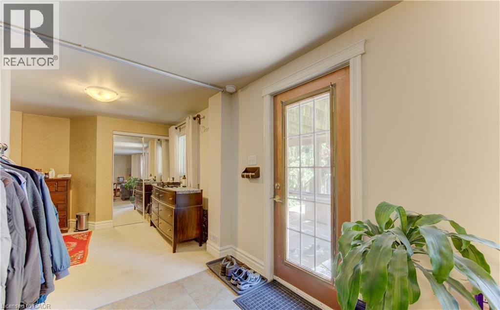 Entryway with a glass-paned wood-finish door, light-toned flooring, and neutral wall tones - 74 Forest Edge Trail, Kitchener, ON