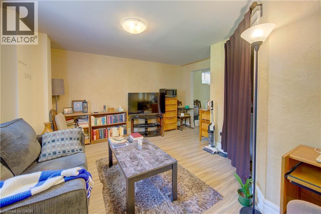 Spacious living area featuring wood-finish flooring, neutral wall tones, and recessed lighting - 74 Forest Edge Trail, Kitchener, ON