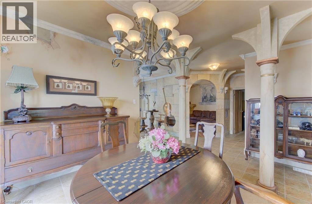 Formal dining area featuring a dark wood-finish oval table, a multi-arm chandelier with frosted glass shades, and light-toned tile flooring - 74 Forest Edge Trail, Kitchener, ON