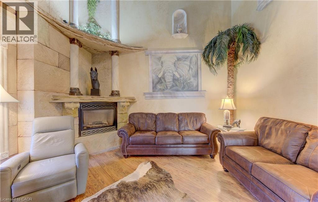 Stone-clad fireplace with a decorative mantel and hearth - 74 Forest Edge Trail, Kitchener, ON