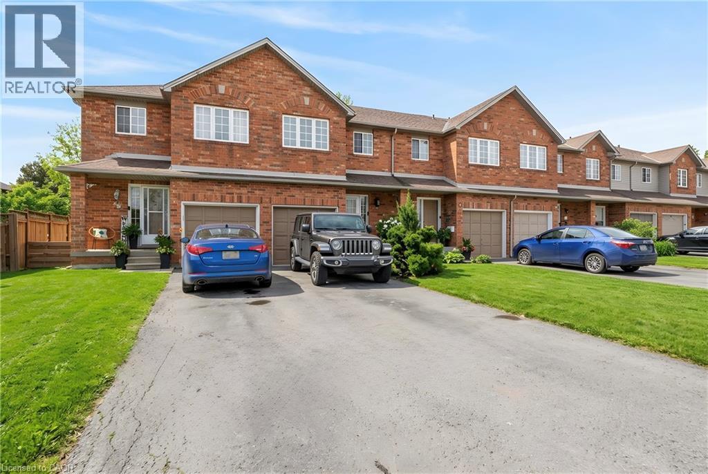 Brick exterior with a gabled roofline, single-car garage, and an asphalt driveway - 10 Cadham Boulevard Unit# 29, Hamilton, ON - Outdoor With Facade