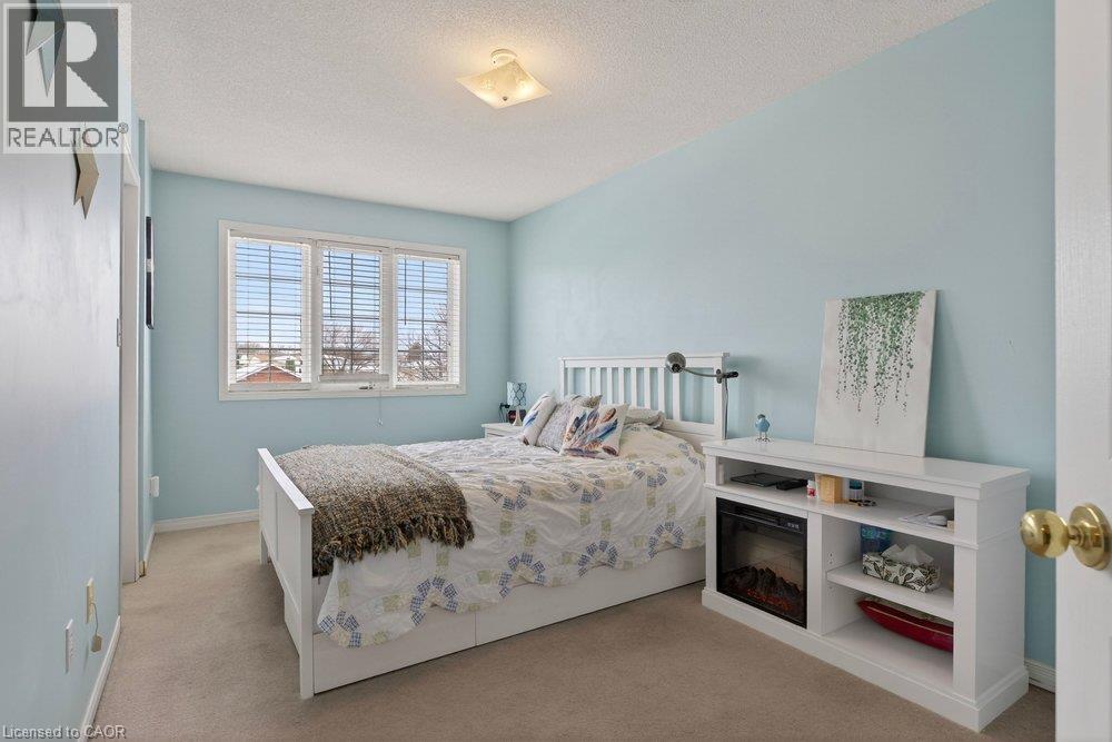 Soft blue wall paint with a textured ceiling - 10 Cadham Boulevard Unit# 29, Hamilton, ON - Indoor Photo Showing Bedroom