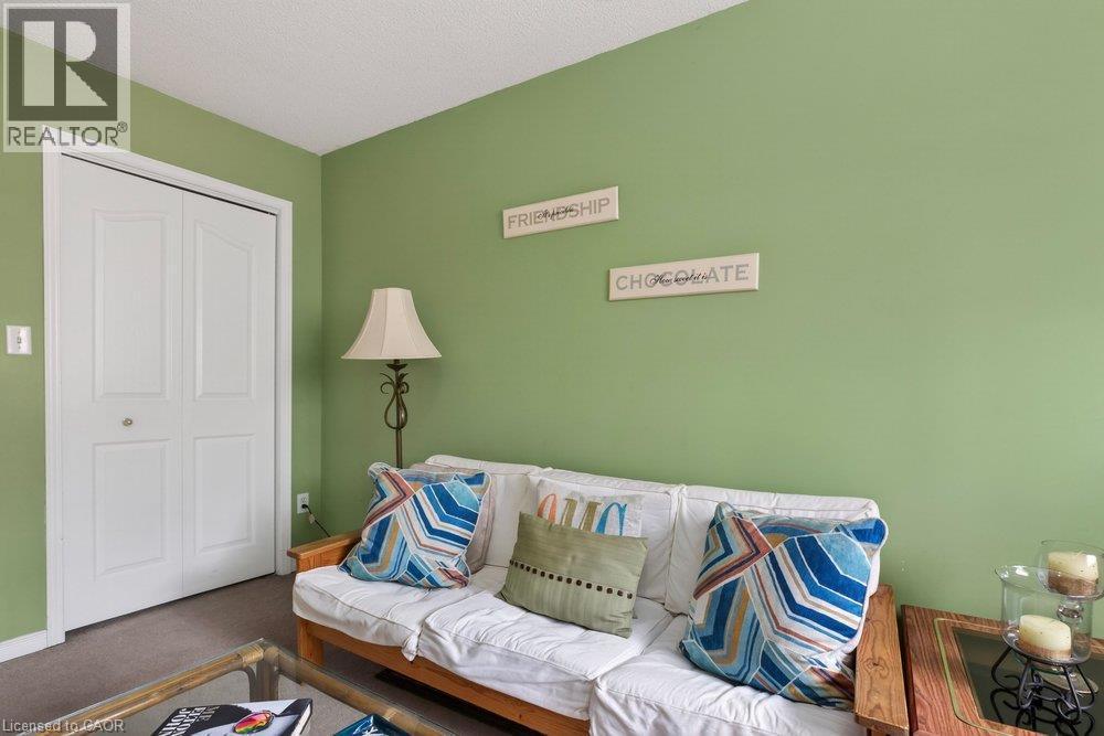 White bi-fold closet doors, green painted walls, and a textured ceiling - 10 Cadham Boulevard Unit# 29, Hamilton, ON - Indoor