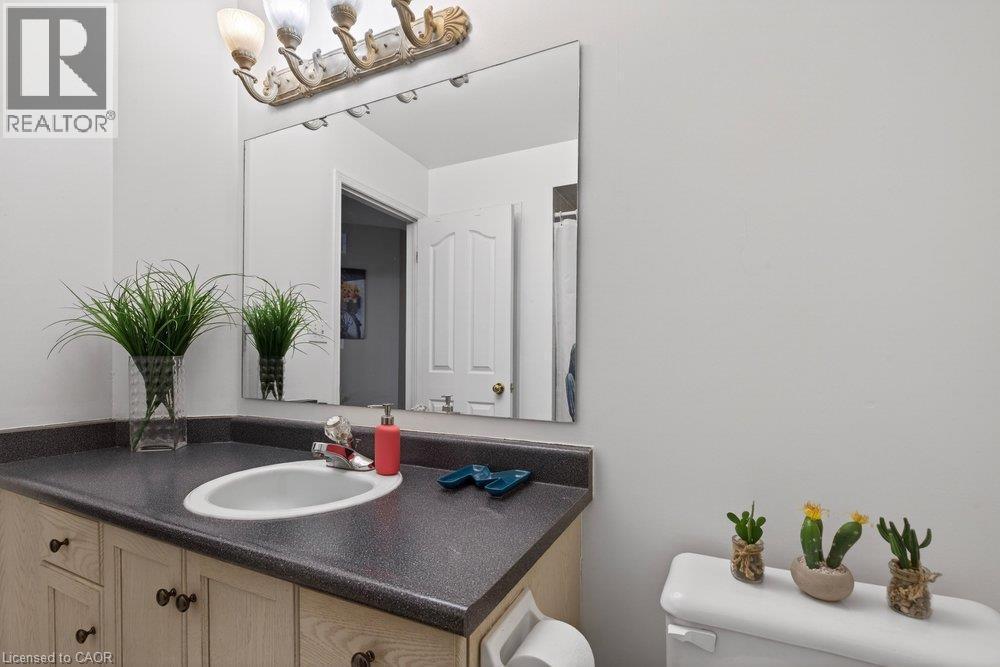 Vanity with an integrated sink, laminate countertop, and wood-finish cabinetry - 10 Cadham Boulevard Unit# 29, Hamilton, ON - Indoor Photo Showing Bathroom