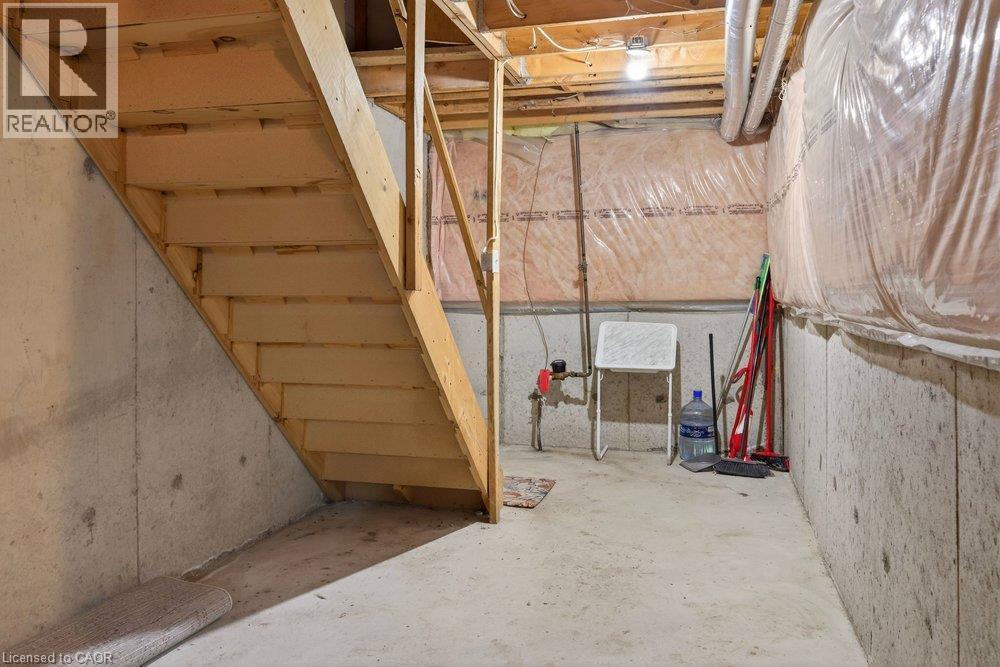 Concrete foundation walls, exposed wood beam ceiling, wood staircase, and concrete flooring - 10 Cadham Boulevard Unit# 29, Hamilton, ON - Indoor Photo Showing Basement