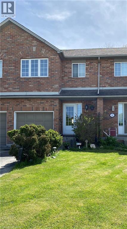 Brick exterior with an attached garage, white front door, and a front lawn - 10 Cadham Boulevard Unit# 29, Hamilton, ON - Outdoor
