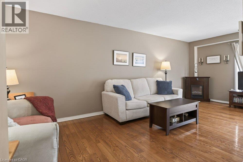 Hardwood flooring throughout, neutral paint colors, and a built-in fireplace - 10 Cadham Boulevard Unit# 29, Hamilton, ON - Indoor Photo Showing Living Room
