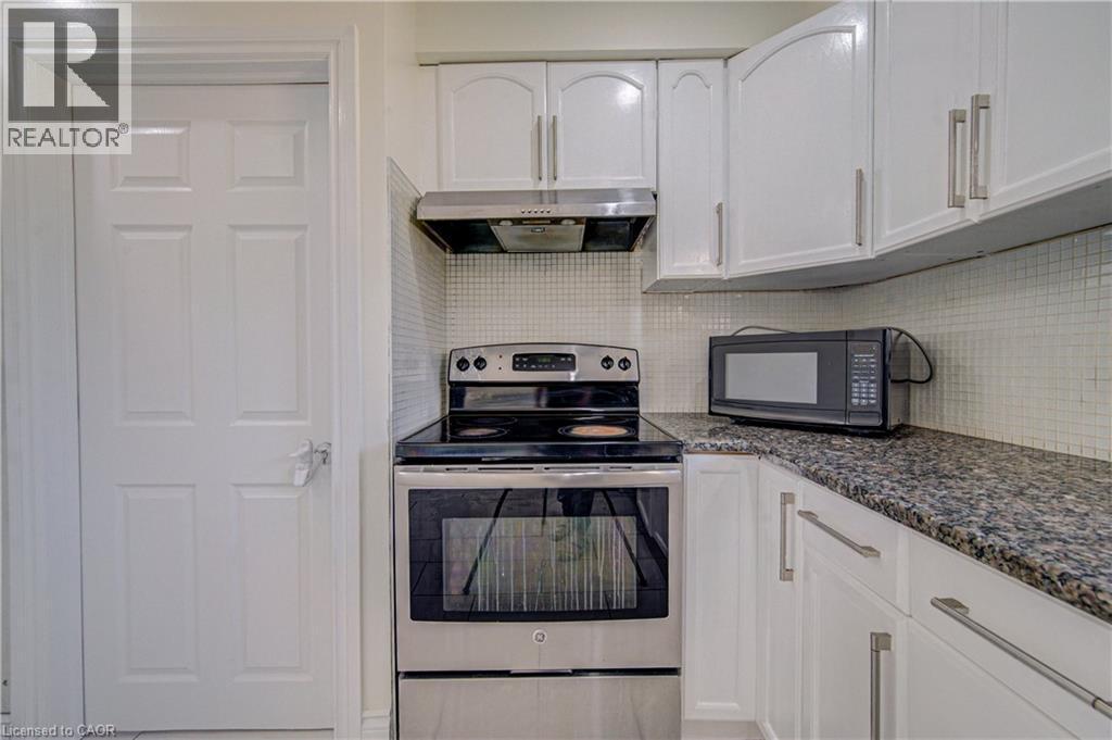 White cabinetry with brushed nickel hardware, stainless steel range, coordinating range hood, and a mosaic tile backsplash - 161 Kipling Avenue, Kitchener, ON - Indoor Photo Showing Kitchen