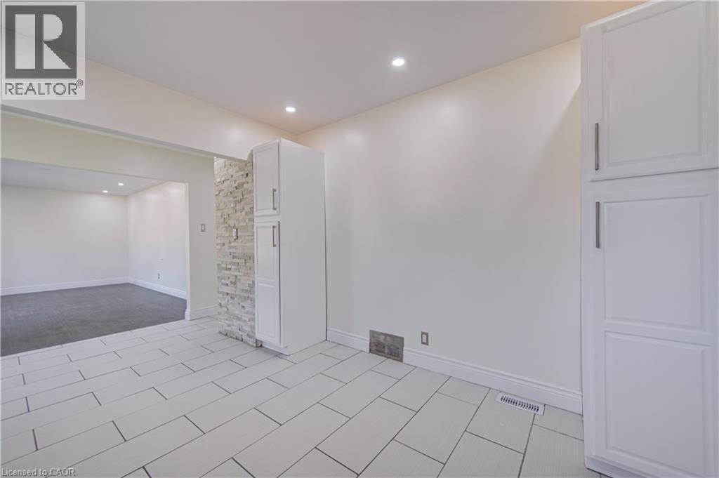 White rectangular tile flooring, recessed ceiling lighting, light-toned walls, and built-in cabinetry with silver-tone hardware - 161 Kipling Avenue, Kitchener, ON - Indoor Photo Showing Other Room
