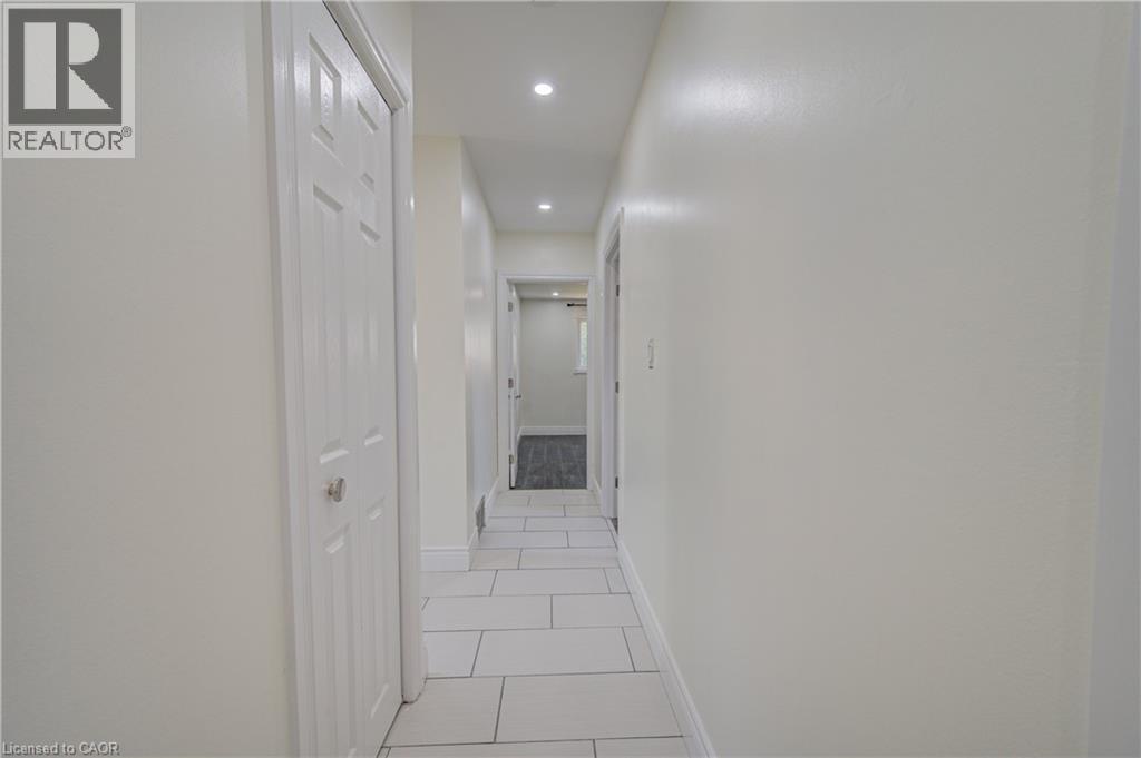 White tile flooring with light gray grout, recessed ceiling lighting, and a paneled interior door - 161 Kipling Avenue, Kitchener, ON - Indoor Photo Showing Other Room