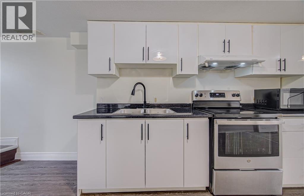 Kitchen featuring white cabinetry, dark countertops, a stainless steel electric range, and a matte black gooseneck faucet - 161 Kipling Avenue, Kitchener, ON - Indoor Photo Showing Kitchen With Double Sink