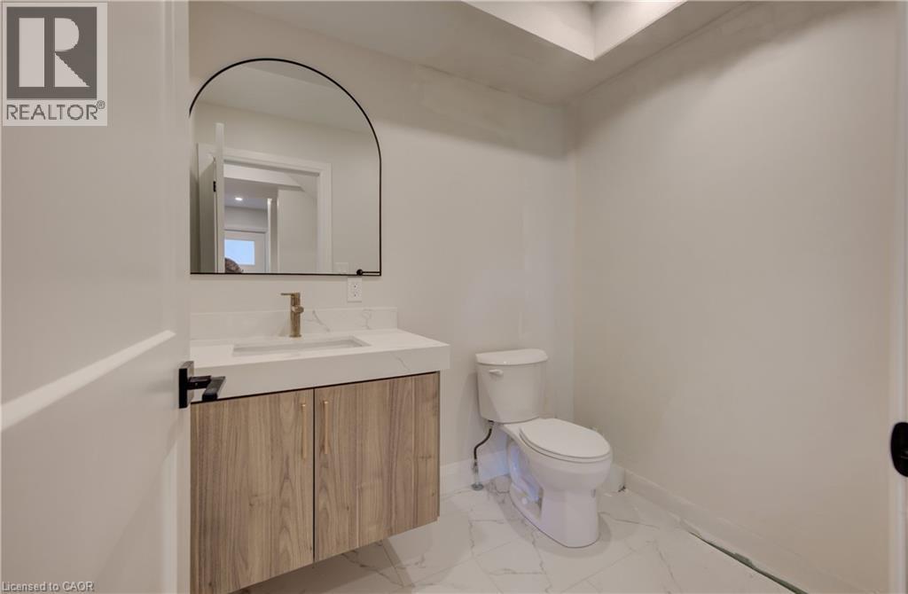 Floating vanity with wood-finish cabinetry, integrated sink, and gold-tone faucet - 34 Moore Avenue N, Waterloo, ON - Indoor Photo Showing Bathroom