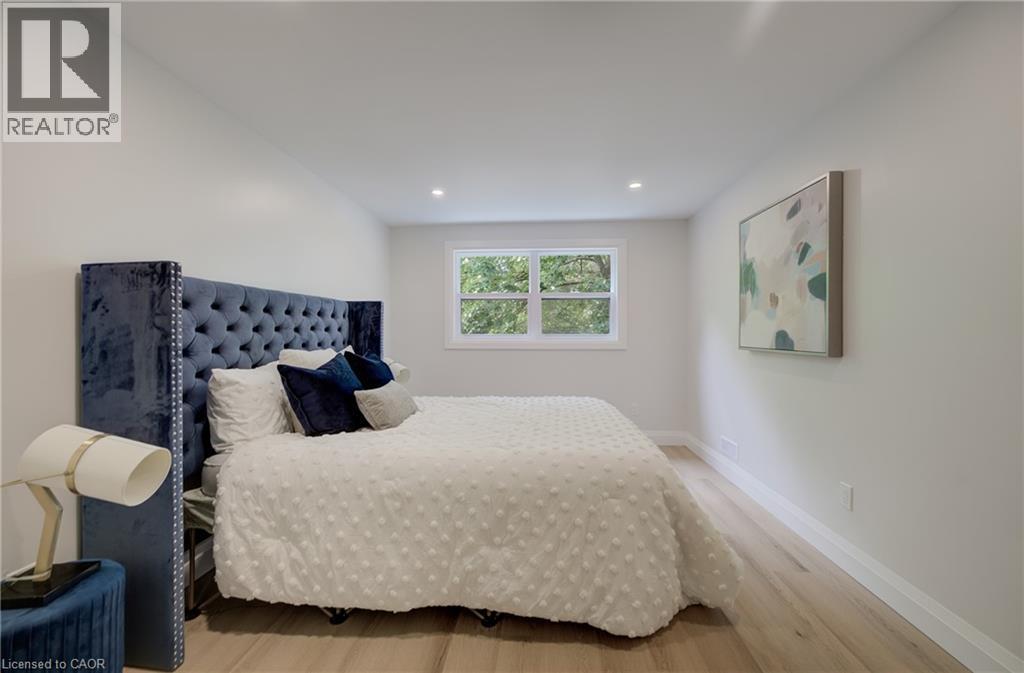 Recessed lighting, light wood-finish flooring, white walls, and a window with white trim - 34 Moore Avenue N, Waterloo, ON - Indoor Photo Showing Bedroom