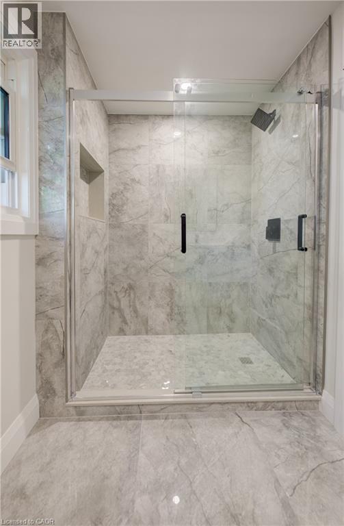 Glass-enclosed shower featuring large format tile walls and flooring - 34 Moore Avenue N, Waterloo, ON - Indoor Photo Showing Bathroom