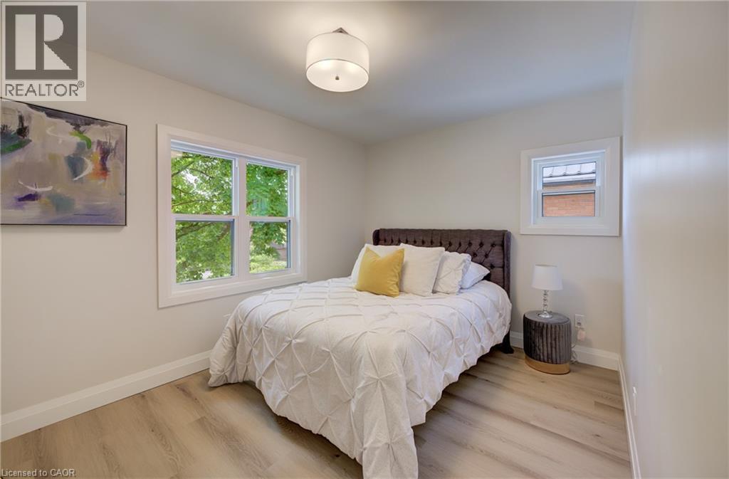 Recessed lighting, wood-finish flooring, white trim, and multiple windows - 34 Moore Avenue N, Waterloo, ON - Indoor Photo Showing Bedroom