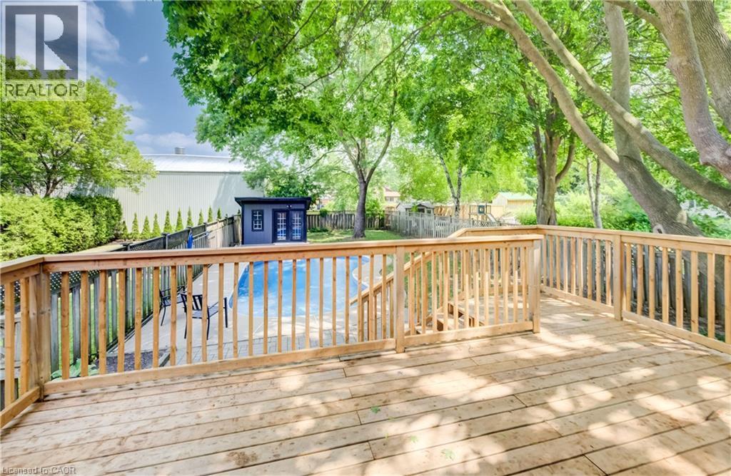 Expansive wooden deck with railing, stairs, and surrounding mature trees - 34 Moore Avenue N, Waterloo, ON - Outdoor With Deck Patio Veranda With Exterior