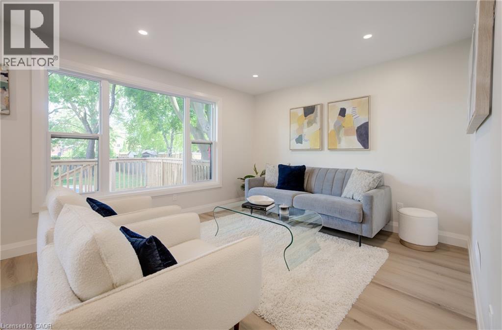 Recessed ceiling lighting, large picture windows, light wood-finish flooring, and white painted walls - 34 Moore Avenue N, Waterloo, ON - Indoor Photo Showing Living Room