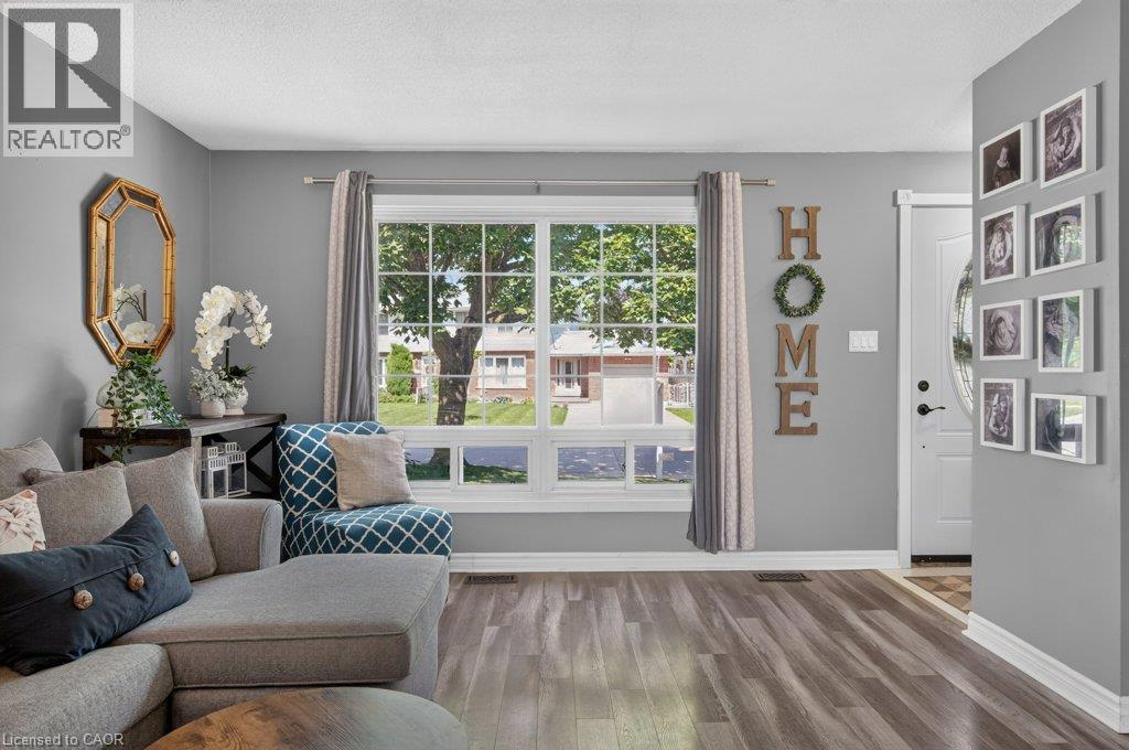 Bright, light-filled living space with expansive glass sliding doors and transom windows framing outdoor scenery - 60 Elford Crescent, Hamilton, ON - Indoor Photo Showing Living Room