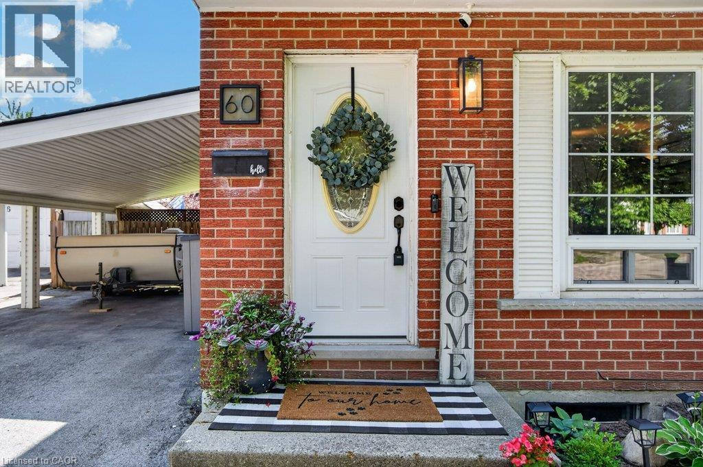Brick exterior with white front door, transom window, and a carport - 60 Elford Crescent, Hamilton, ON - Outdoor With Exterior