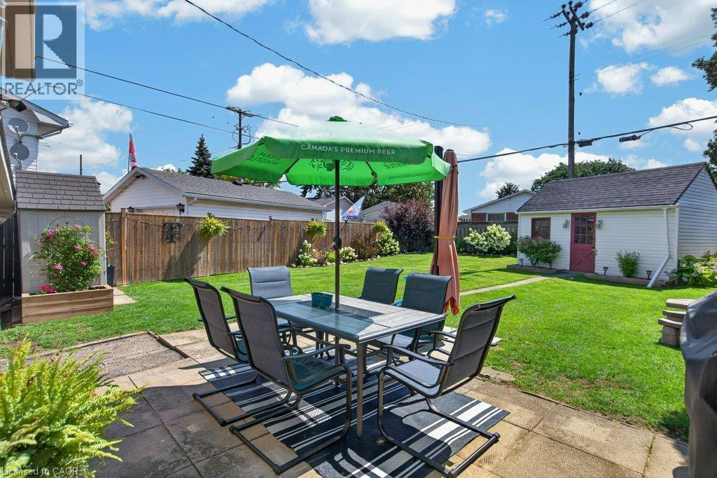 Expansive grass lawn, concrete patio, privacy fencing, detached storage shed, and mature plantings - 60 Elford Crescent, Hamilton, ON - Outdoor With Deck Patio Veranda