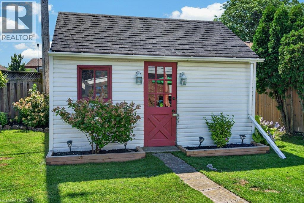 Charming cottage-style home featuring a distinctive red Dutch door entry, white horizontal siding, and a pitched roof with dark shingles - 60 Elford Crescent, Hamilton, ON - Outdoor