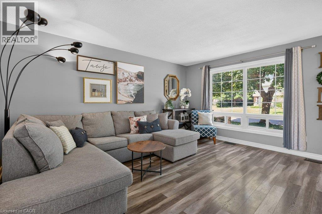 Bright, light-filled living room with expansive sliding glass doors and transom windows framing natural landscaping - 60 Elford Crescent, Hamilton, ON - Indoor Photo Showing Living Room