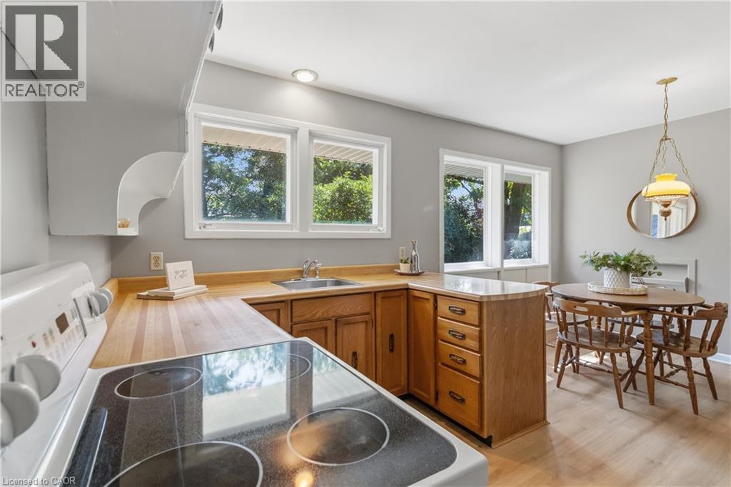 Bright, open kitchen featuring wood-finish cabinetry, wood countertops, and stainless steel appliances including a cooktop with dual burners - 974 Unsworth Avenue, Burlington, ON