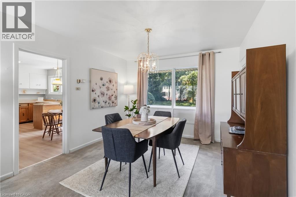 Dining area featuring a modern chandelier, large window, and light-toned wall paint - 974 Unsworth Avenue, Burlington, ON
