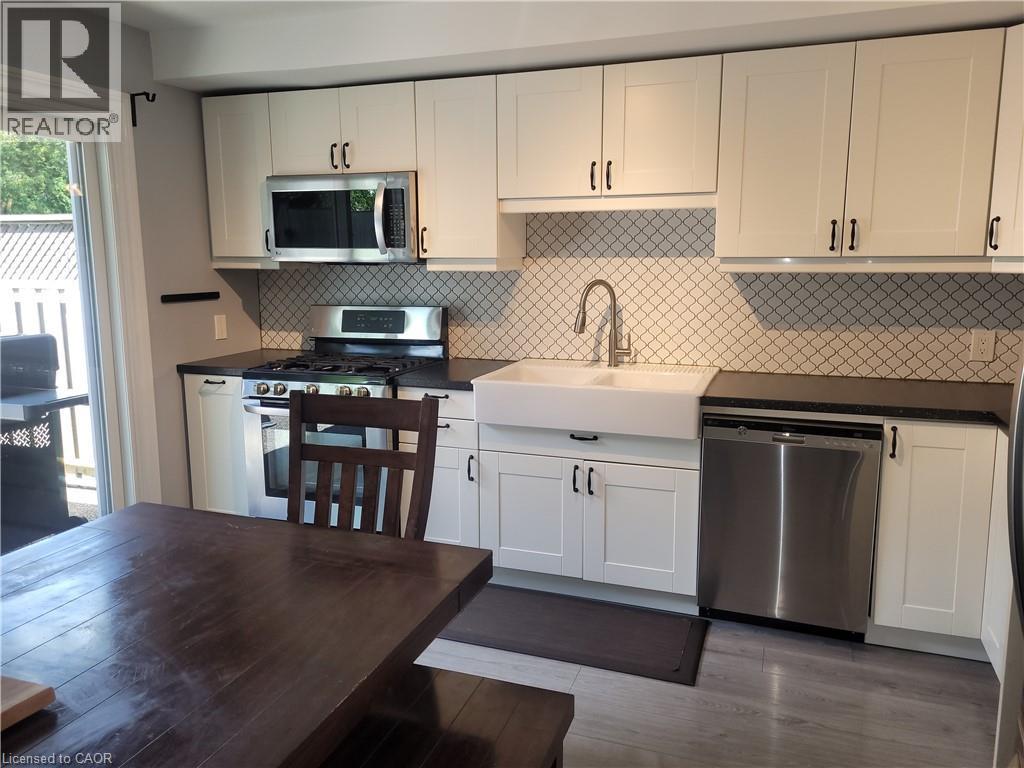 Updated Kitchen with Shaker-Style Cabinetry, Stainless Steel Appliances, and Quartz Countertops This bright kitchen features crisp white cabinetry with brushed nickel hardware, a geometric tile backs - 23 Bentley Place, Hamilton, ON - Indoor Photo Showing Kitchen With Stainless Steel Kitchen