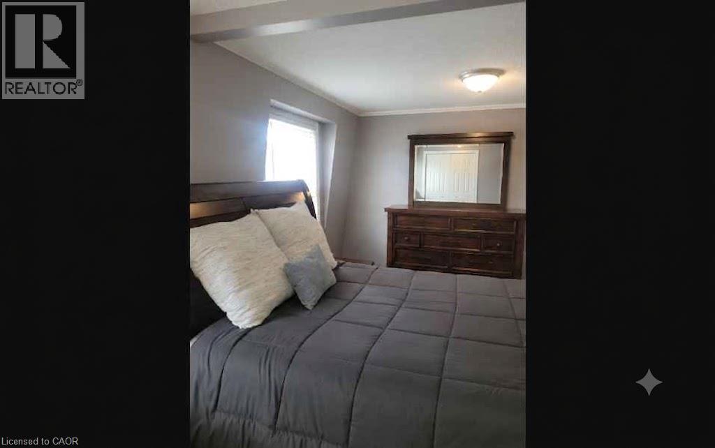 Neutral-toned walls complement a contemporary ceiling light fixture - 23 Bentley Place, Hamilton, ON - Indoor Photo Showing Bedroom