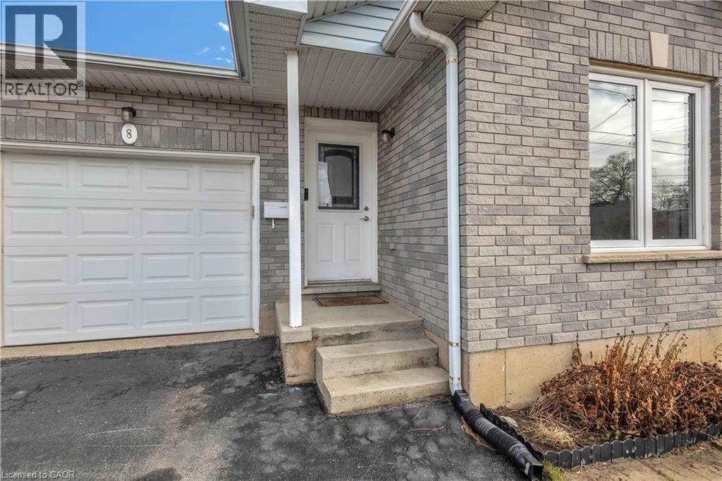Doorway to property featuring a garage, brick siding, and asphalt driveway - 8 Brantdale Avenue, Hamilton, ON - Outdoor With Exterior