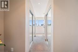 Hallway with neutral wall tones, recessed lighting, and mirrored closet doors - 