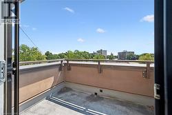 Private balcony featuring a concrete floor, stucco-finish wall, and metal railing - 