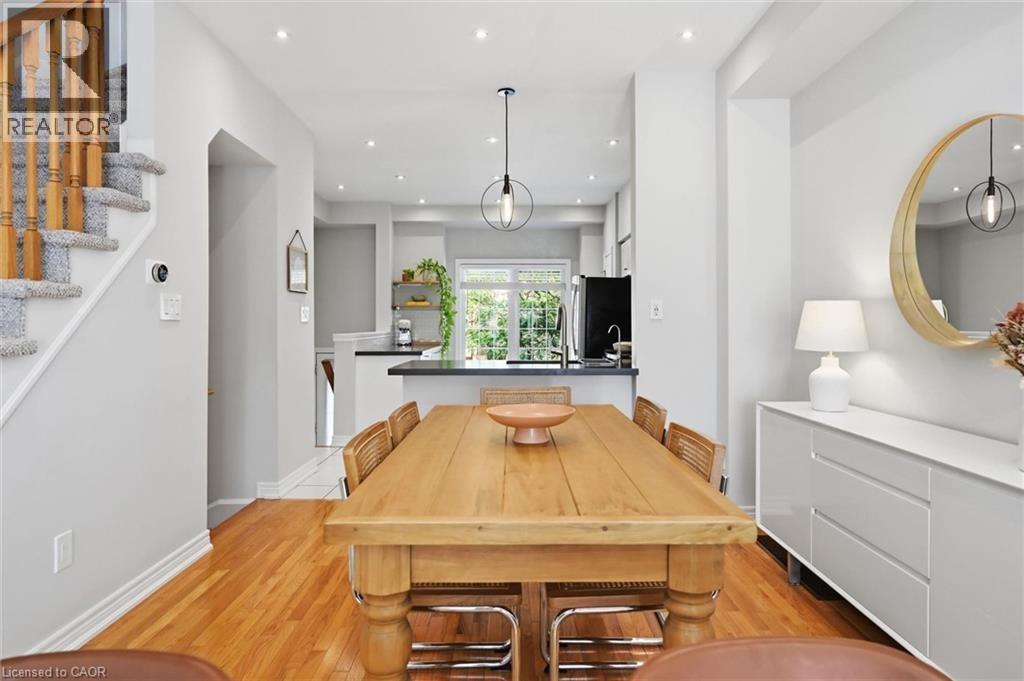 Open-concept living space featuring wood-finish flooring, recessed lighting, and a modern pendant light fixture - 678 Rowley Common, Burlington, ON - Indoor Photo Showing Dining Room