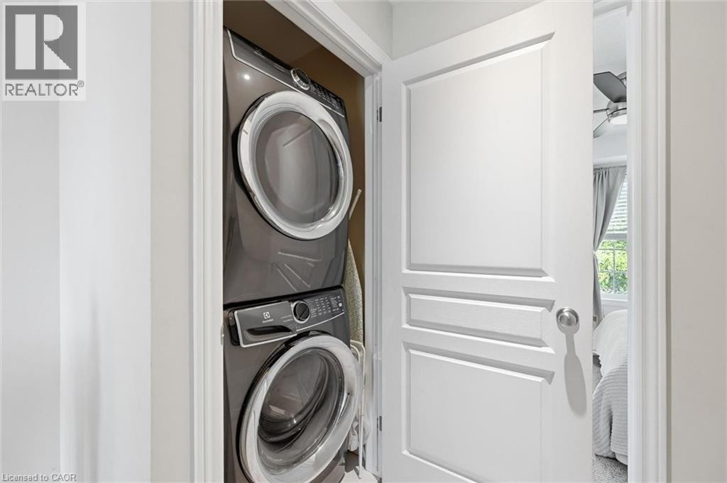 Dedicated laundry closet featuring a stacked washer and dryer, providing functional utility - 678 Rowley Common, Burlington, ON - Indoor Photo Showing Laundry Room