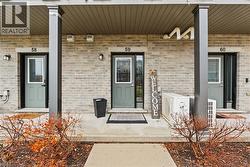 Doorway to property featuring covered porch and brick siding - 