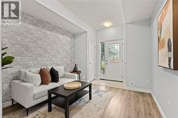 Living room with light wood finished floors and brick wall - 