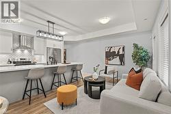 Living area featuring light wood-type flooring and a tray ceiling - 